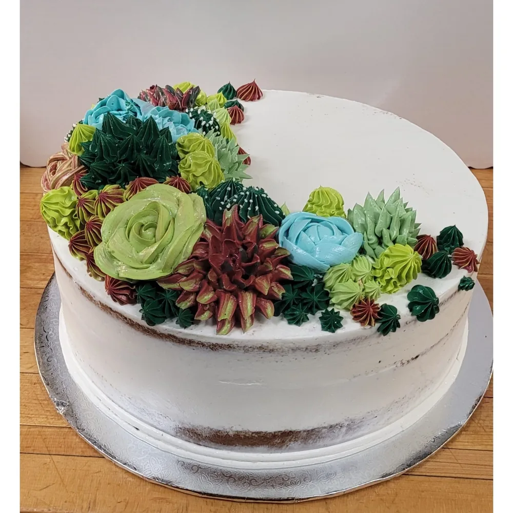 A semi-naked cake topped with piped succulents