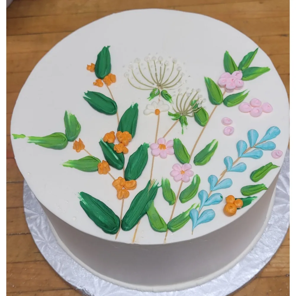 A white cake hand-painted with wildflowers